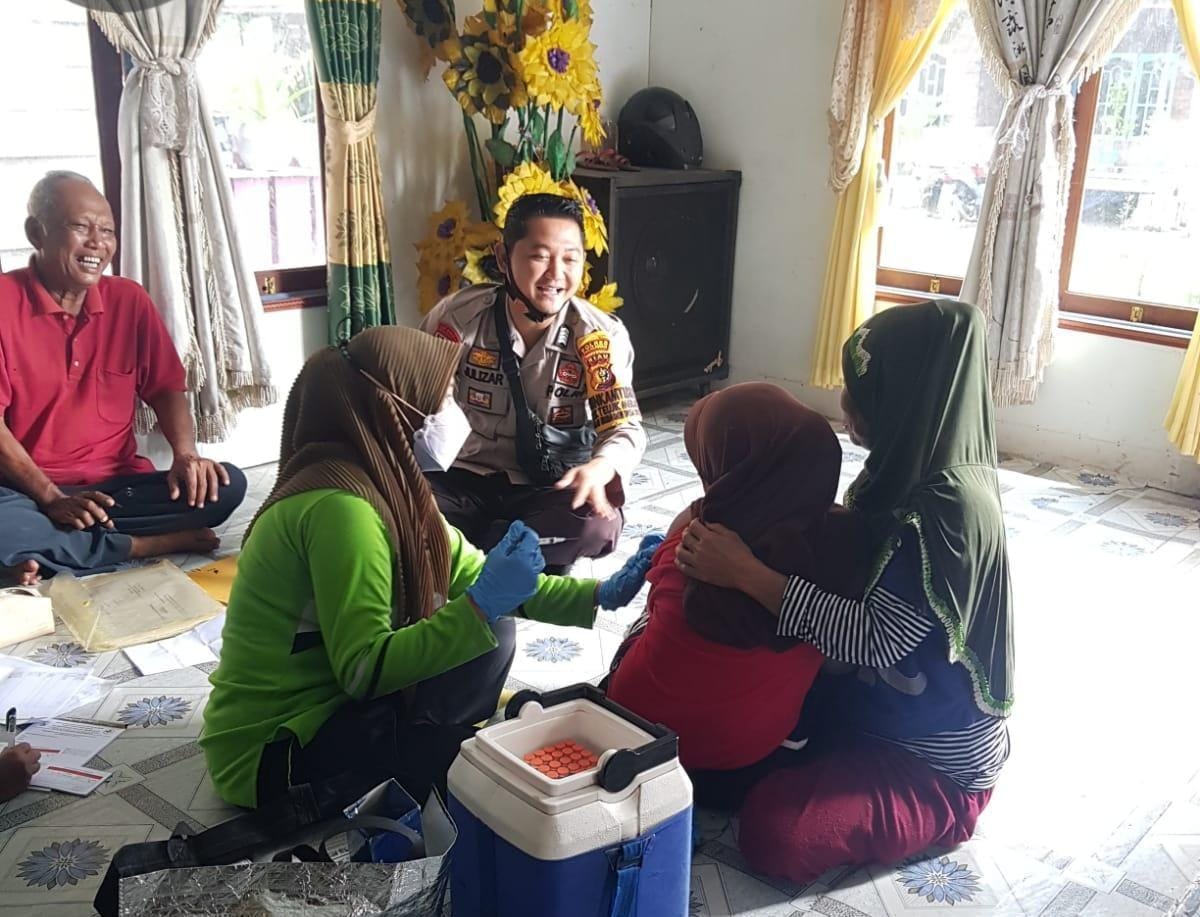 Personil Bhabinkamtibmas Bersinergi Bersama Nakes Puskesmas Melaksanakan Door to door Dirumah Warga